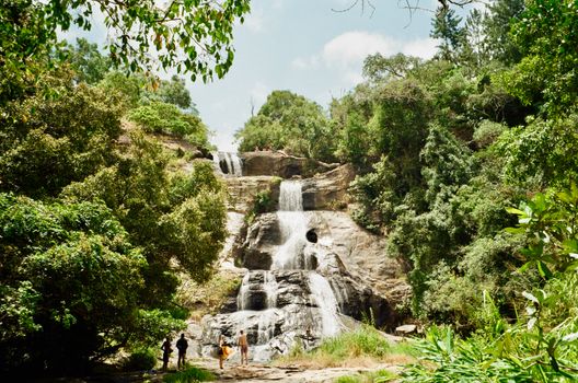 Explore the tranquil beauty of a cascading waterfall in Sri Lanka surrounded by lush, vibrant greenery.