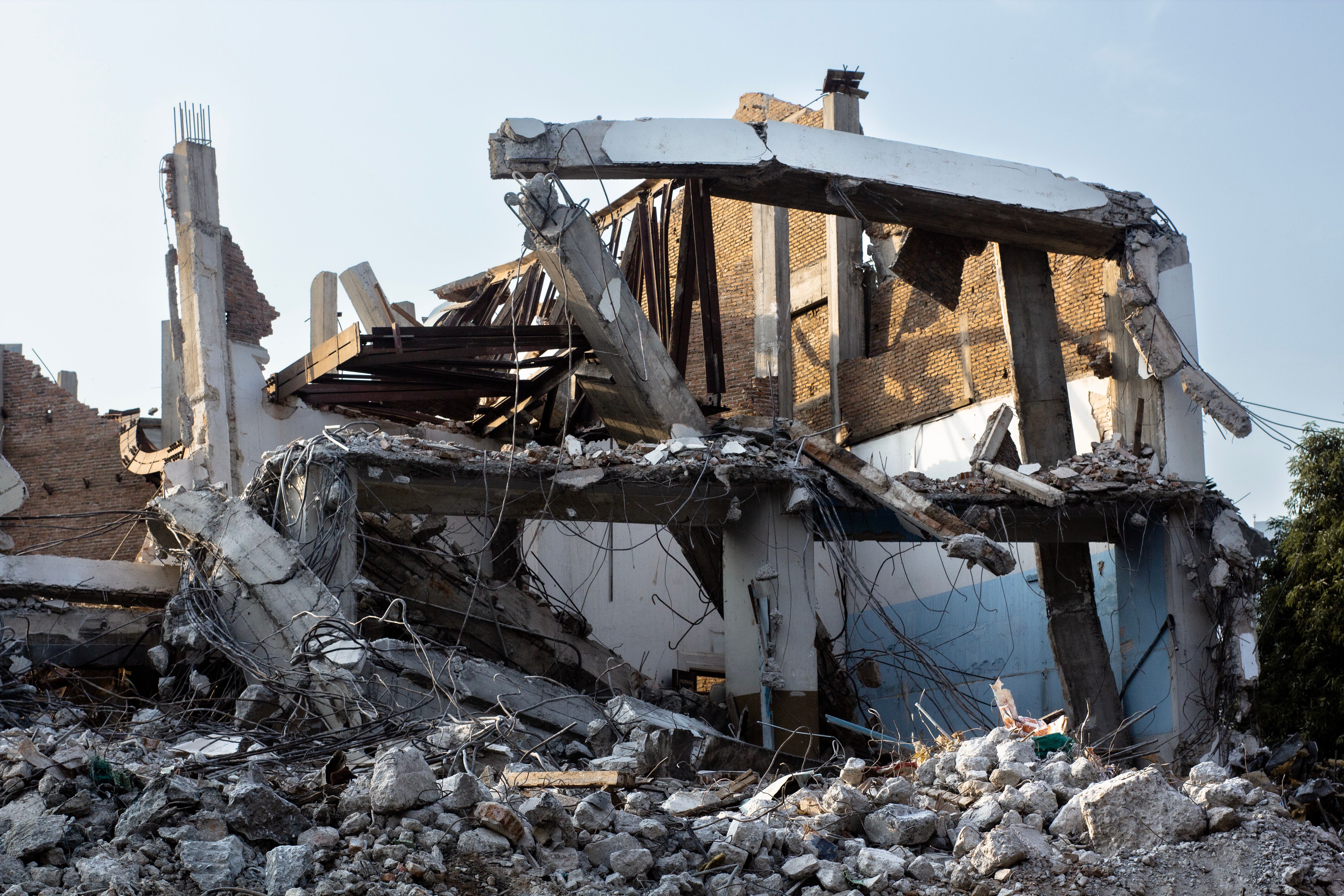 A partially demolished building with exposed beams and rubble.
