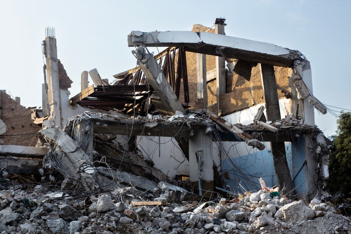 Partially demolished building with exposed beams and rubble