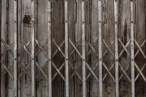 Free Close-up of a rusty metal gate with a grunge texture, showing intricate latticework. Stock Photo