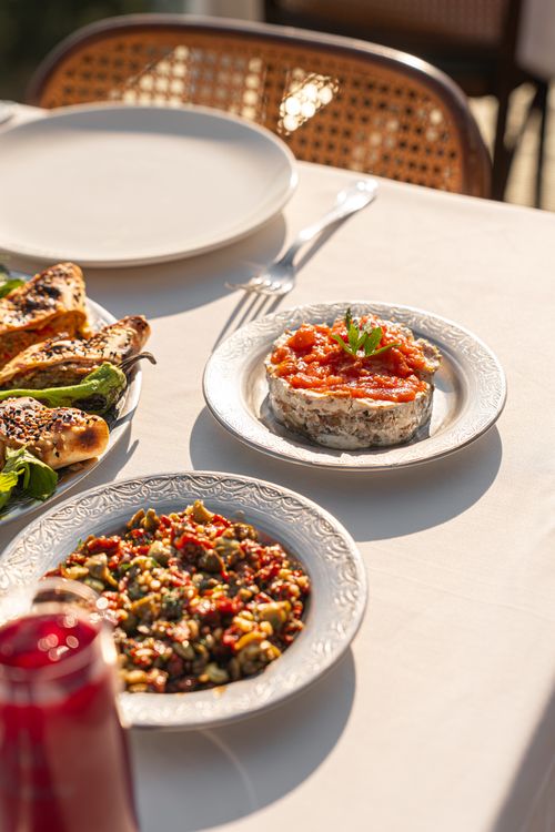 Free A beautifully set outdoor dining table featuring diverse gourmet dishes in natural sunlight. Stock Photo