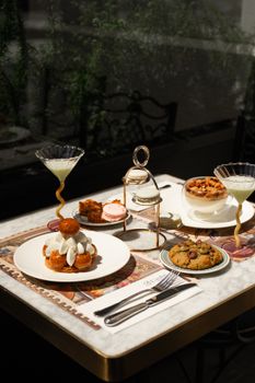 An elegant display of desserts and cocktails on a stylishly set table indoors.