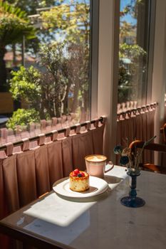 A bright and inviting cafe table with a dessert and coffee in natural light.