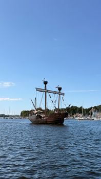 A vintage sailboat sailing in Rostock, Germany on a sunny day.