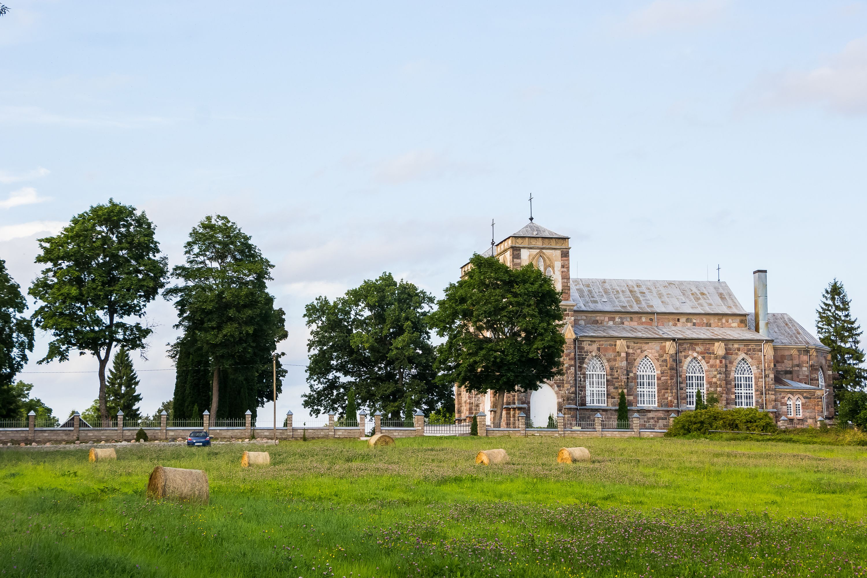 A beautiful stone church with gothic architecture in a rural setting.