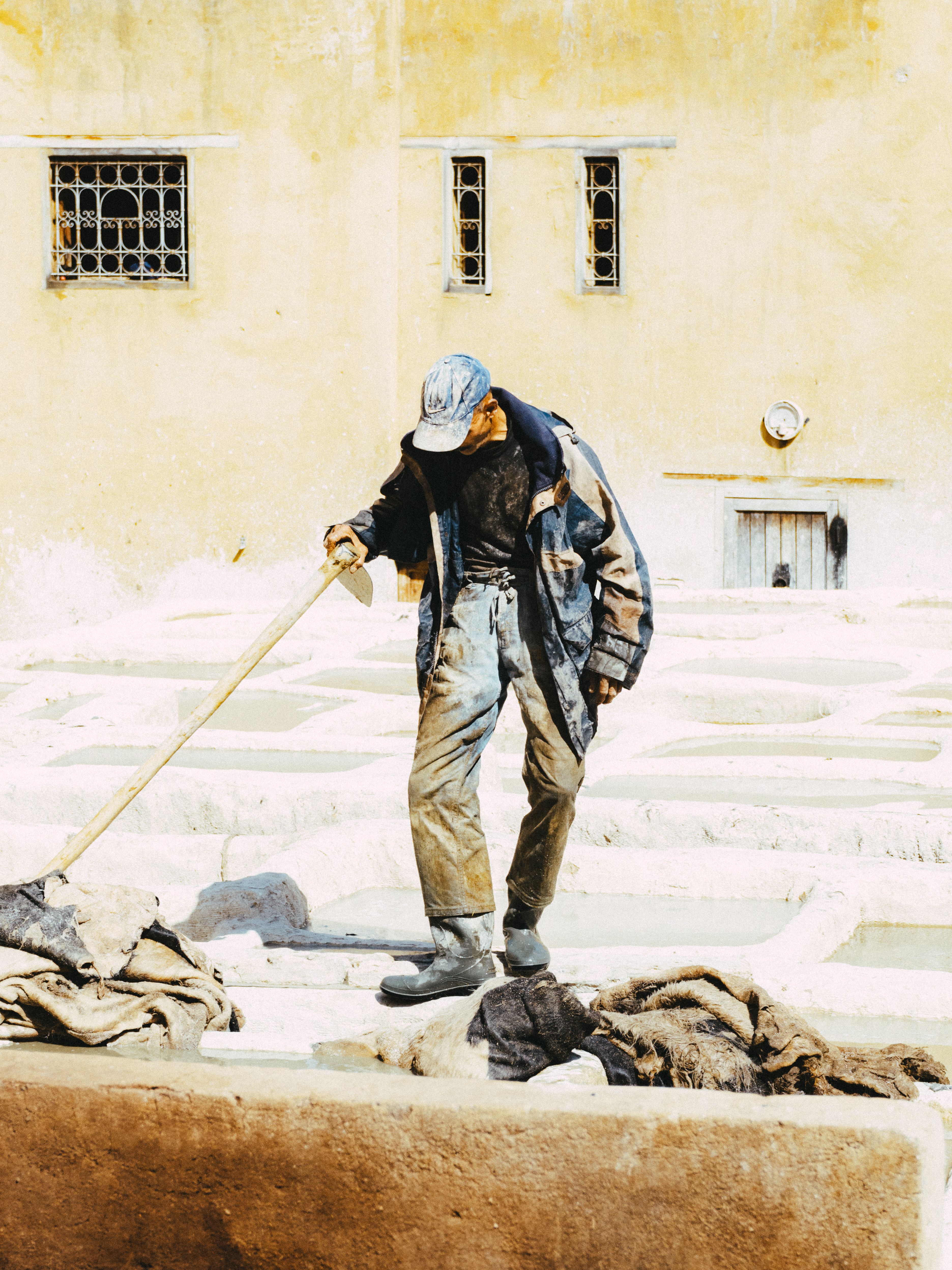 A man working in the historic tanneries of Fes, Morocco, showcasing traditional leather processing techniques.