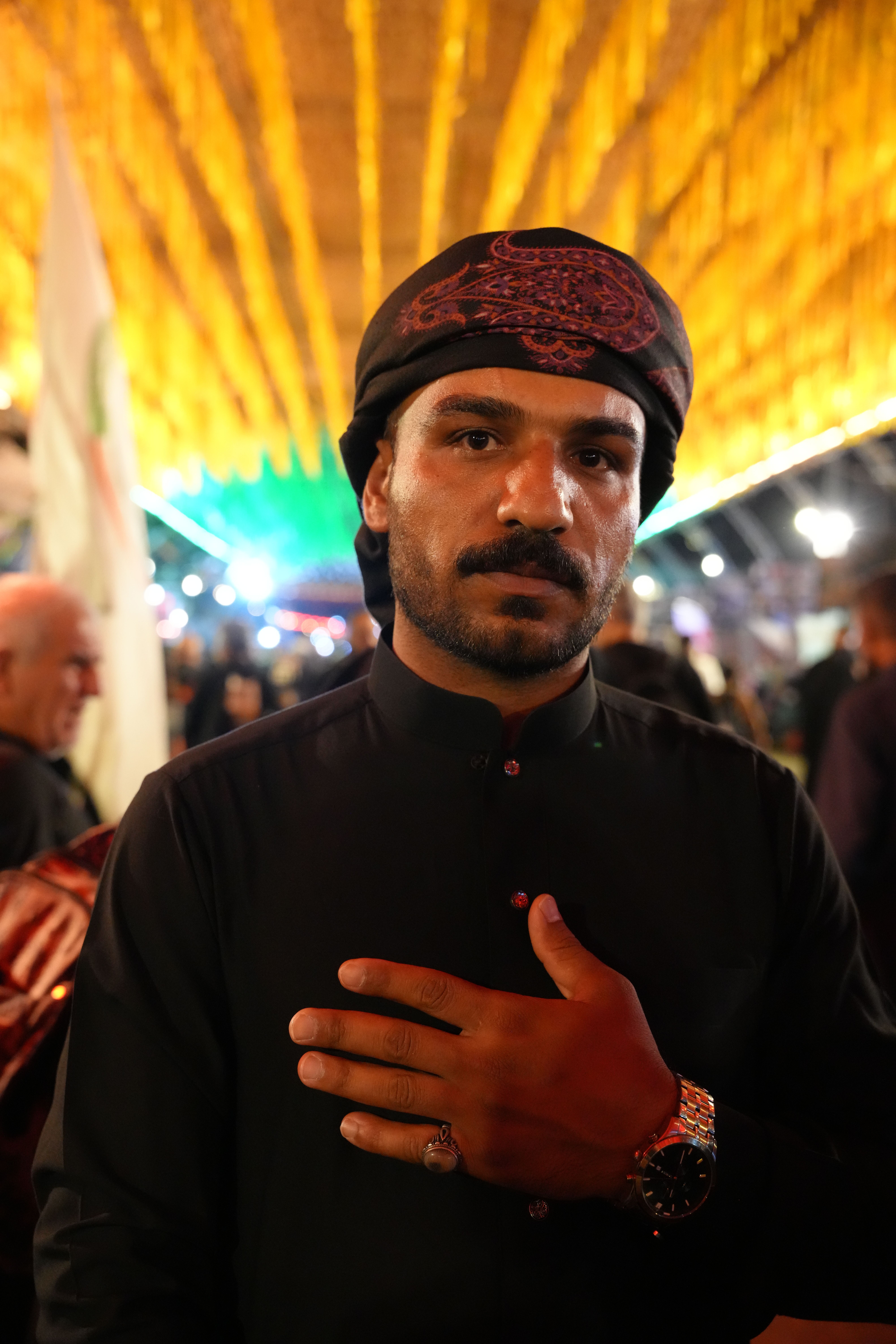 Portrait of a man during the Arbaeen pilgrimage in Karbala, Iraq, adorned with traditional attire.