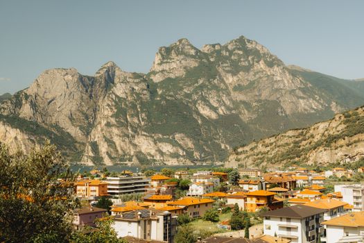 Charming Italian town nestled below majestic mountains in a sunny landscape.