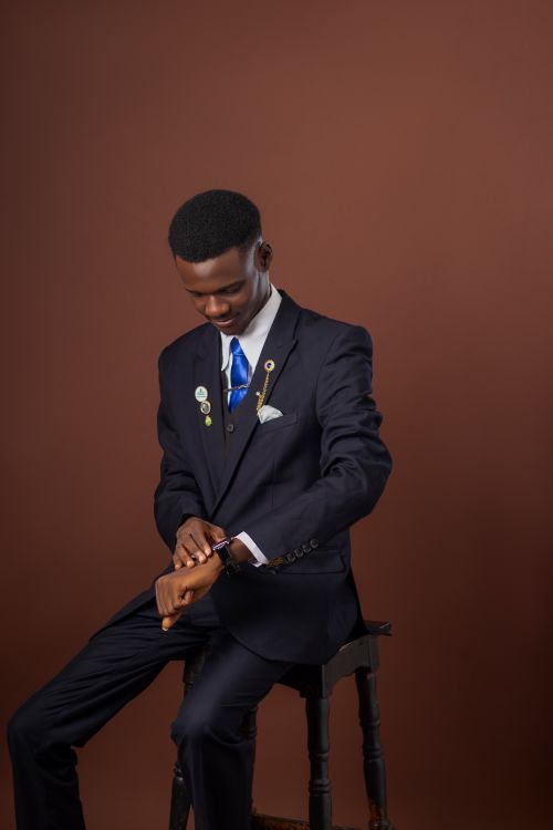 Free Young professional in a dark suit looking at wristwatch on an elegant background. Stock Photo