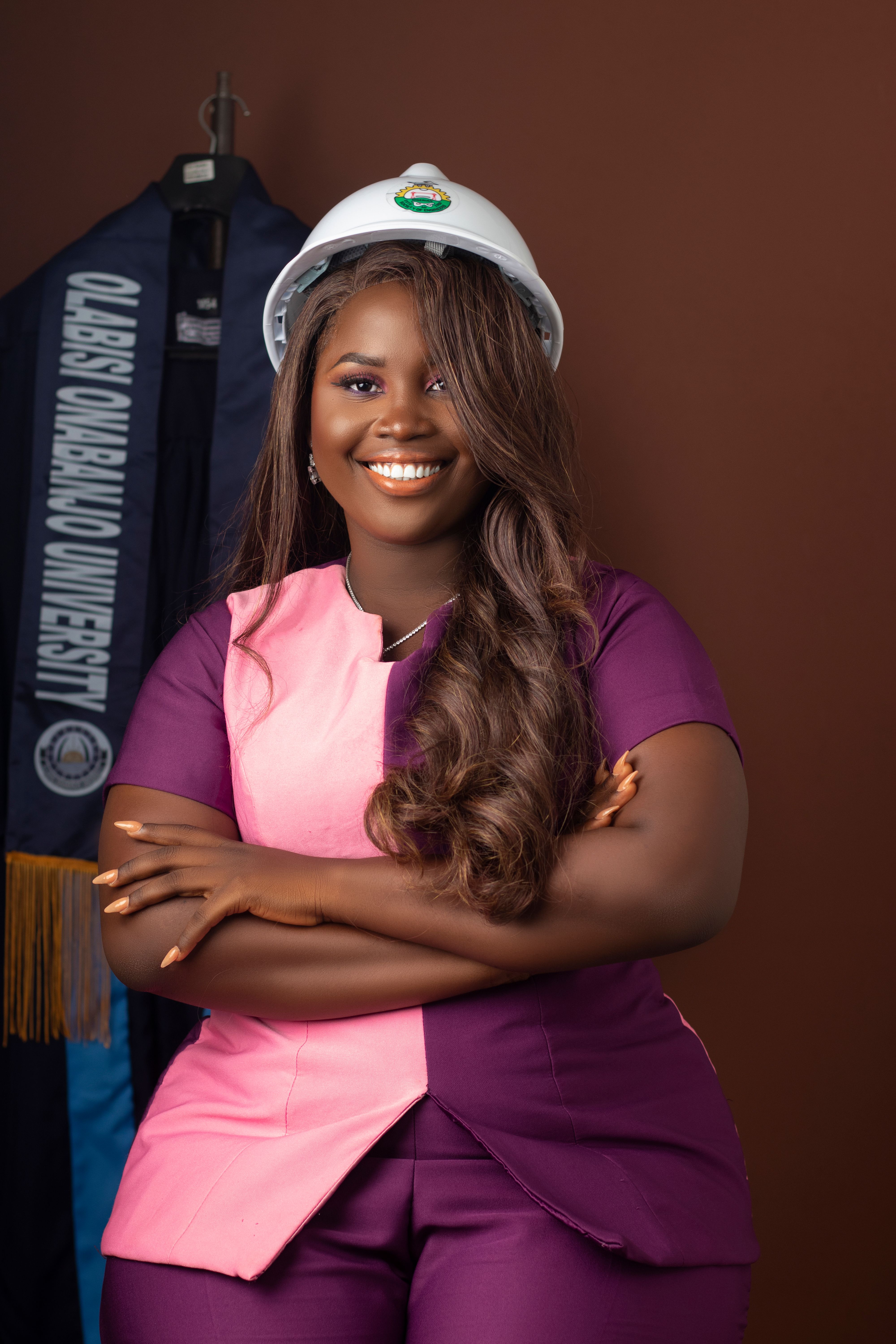 Smiling female graduate in a hard hat, showcasing her achievement in construction studies.