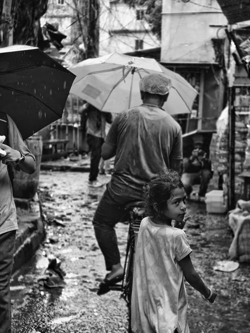 Free A black and white street scene during rain in Kolkata, India, depicting daily life. Stock Photo
