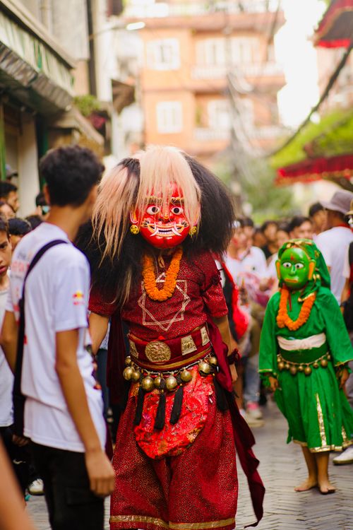 Free Vibrant festival scene featuring masked dancers in traditional attire among a crowd. Stock Photo