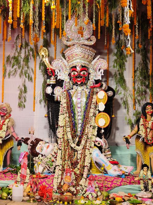 Free Colorful depiction of Goddess Kali surrounded by festive ornaments in a traditional Indian setting. Stock Photo
