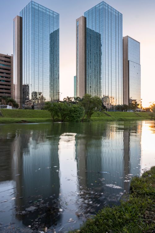 Free Reflection of modern skyscrapers on a tranquil pond at sunset in Rio Grande do Sul, Brazil. Stock Photo