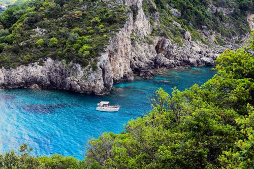 Free Explore the stunning turquoise waters and lush cliffs of Corfu, Greece on a tranquil boat ride. Stock Photo