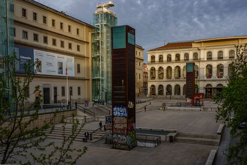 Vista al atardecer de la entrada del Museo Reina Sofía en Madrid, que muestra su arquitectura moderna.