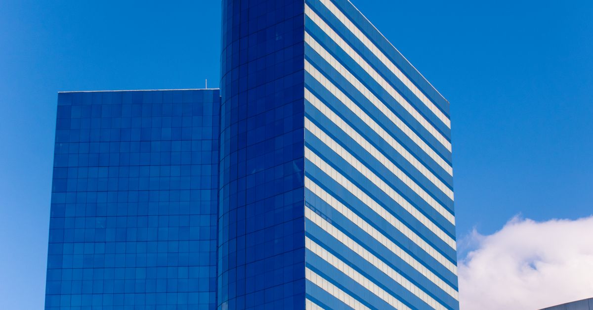 Contemporary glass skyscraper against a blue sky in São Paulo, Brazil.