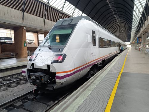 Free A modern passenger train at Sevilla Santa Justa station under a glass roof on a clear day. Stock Photo