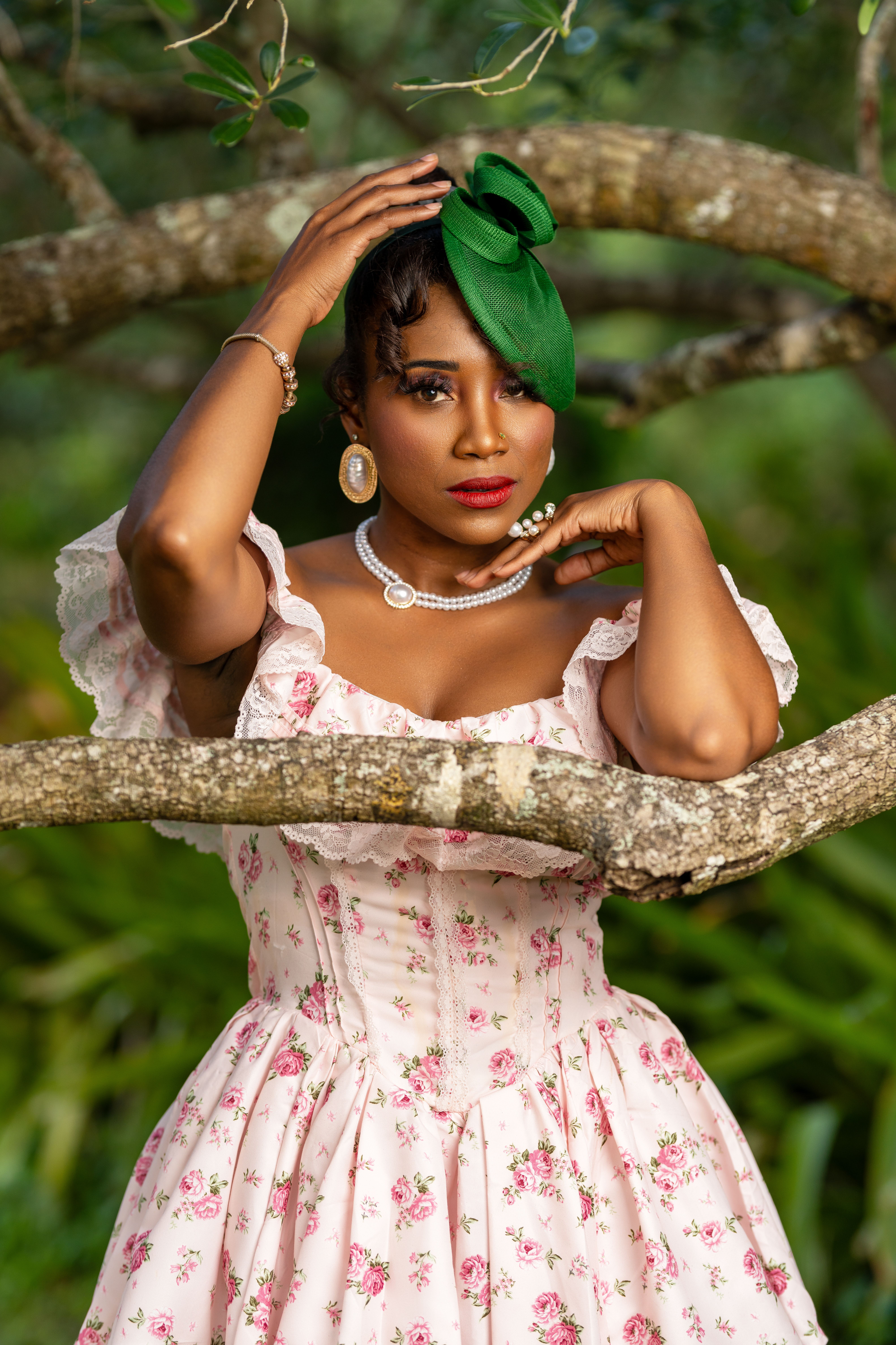 A stylish woman in vintage floral dress and hat poses gracefully outdoors.
