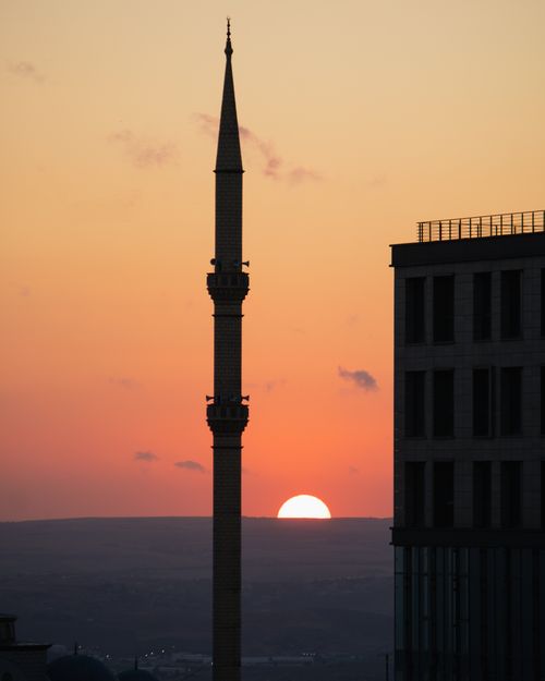 Free Sunset view in Istanbul with silhouette of mosque minaret and modern building. Stock Photo