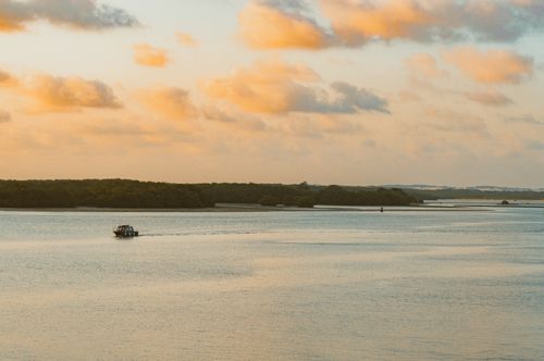 Free A serene boat ride on Potengi River during a vibrant sunset in Rio Grande do Norte, Brazil. Stock Photo