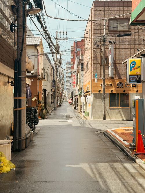 Free A quiet side street in Tokyo, showcasing urban architecture and everyday life in a Japanese neighborhood. Stock Photo