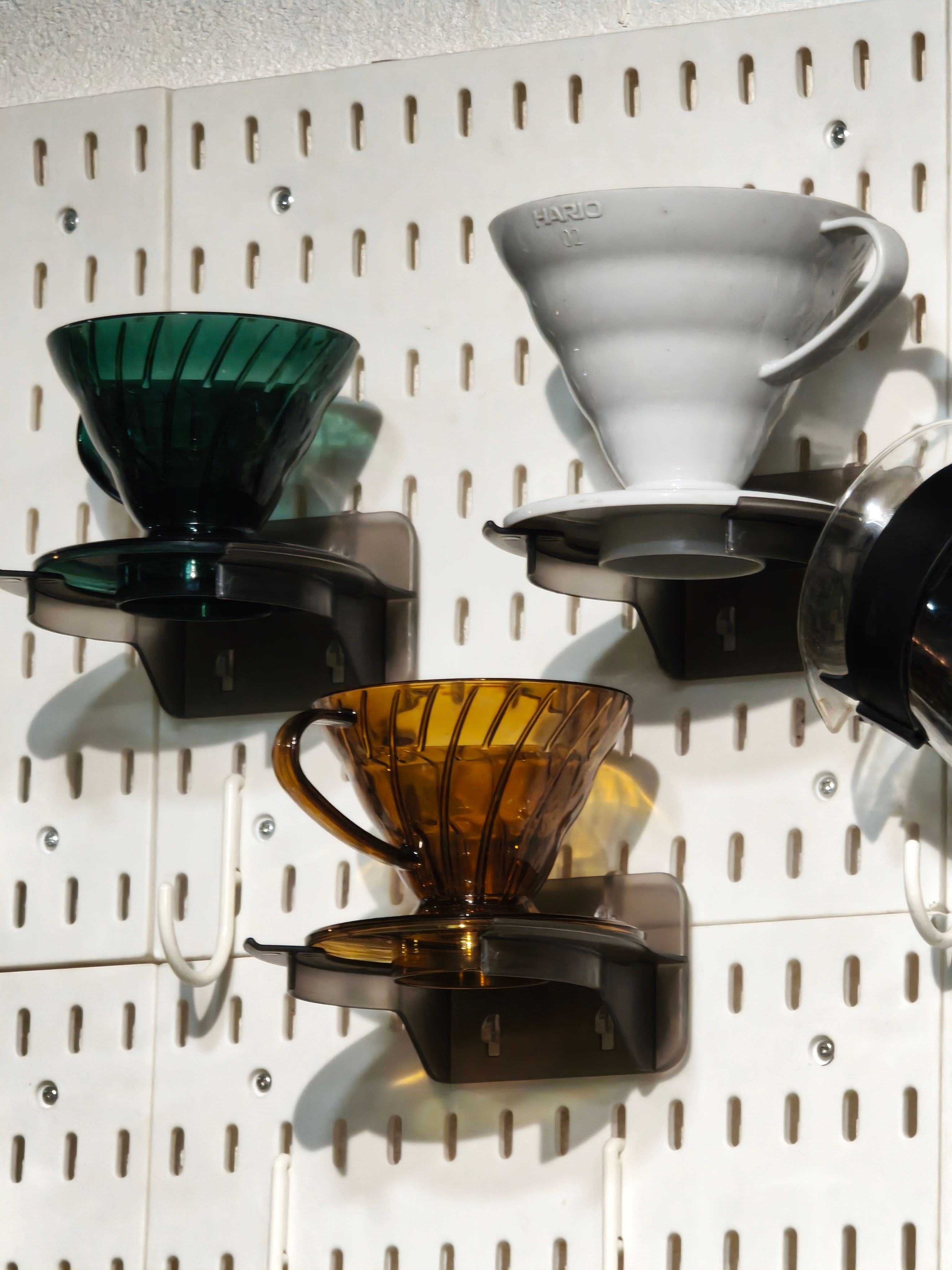 wall mounted pegboard in a kitchen corner organized as a small coffee bar
