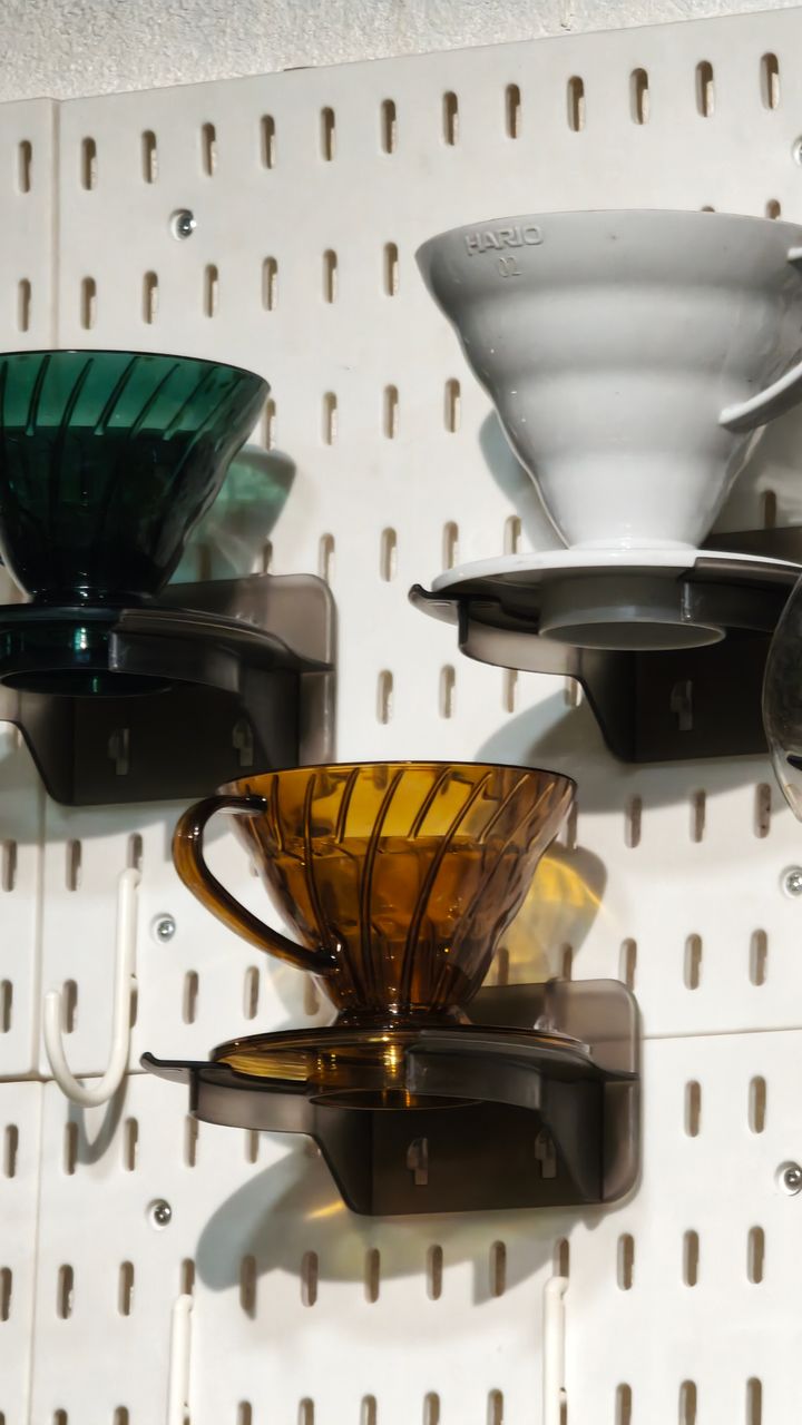 wall mounted pegboard in a kitchen corner organized as a small coffee bar