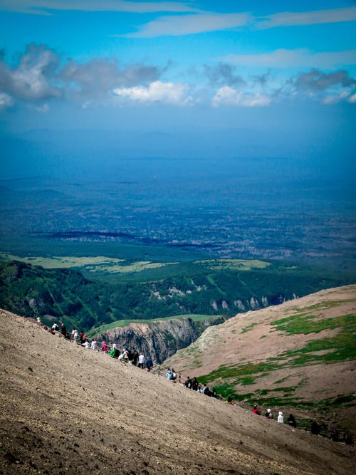 Free A group of hikers walking along a scenic mountain ridge with distant views and a bright sky. Stock Photo