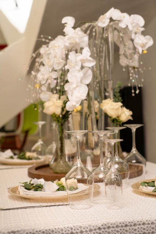 Free Elegant table setting with white orchids and roses, perfect for weddings or special events. Stock Photo