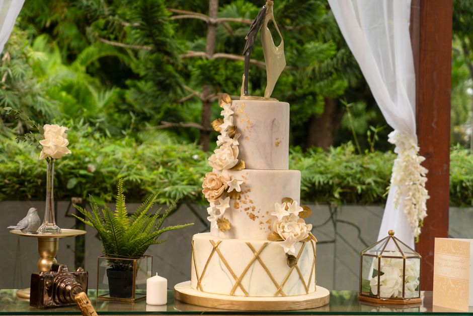 Three-tier wedding cake with fresh flowers on a table