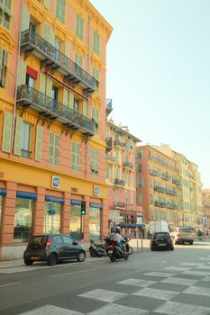A vibrant street scene showcasing classic French architecture with colorful buildings and bustling street life.