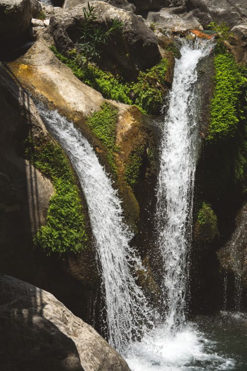Free Beautiful twin waterfalls cascading over rocks surrounded by vibrant green foliage in a natural setting in Türkiye. Stock Photo