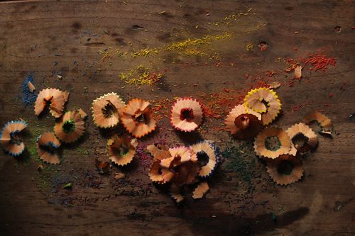 Free Vibrant pencil shavings scattered artfully on a textured wooden surface. Stock Photo