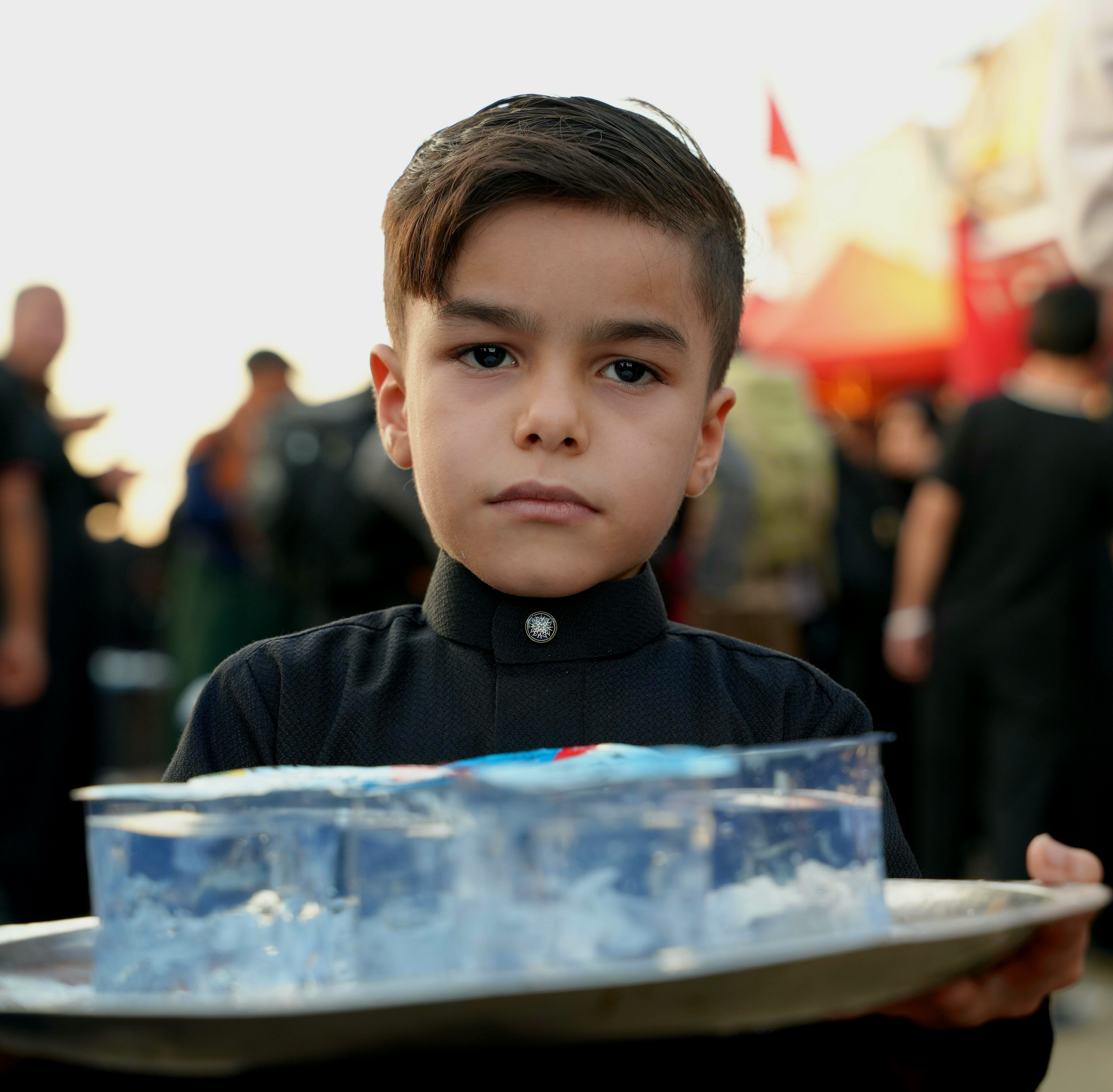 A young boy holding a tray participates in the Arbaeen pilgrimage in Karbala, Iraq.