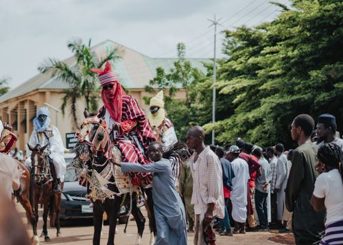 Free Vibrant cultural festival featuring traditionally dressed horsemen and a crowd of spectators. Stock Photo