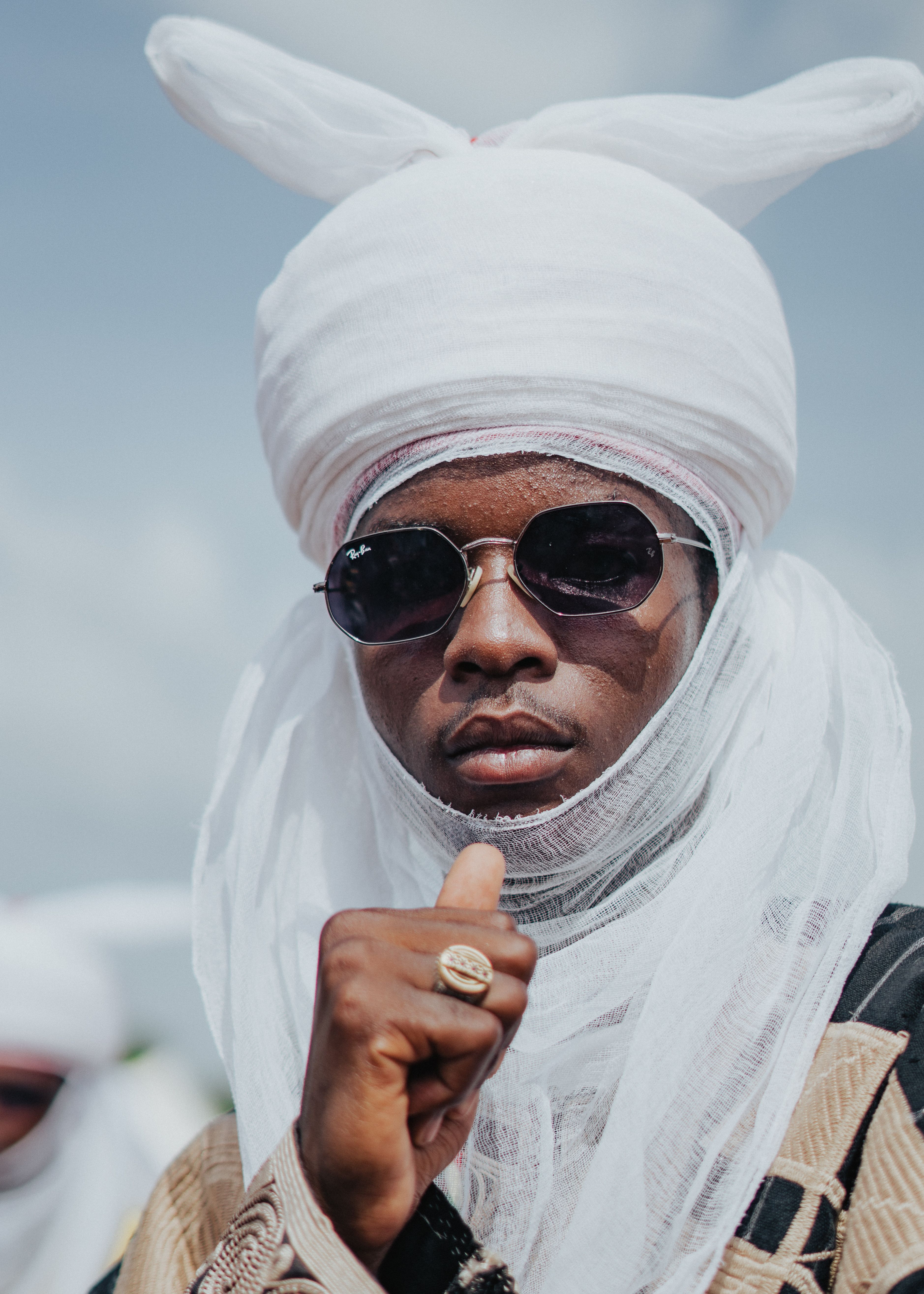 Portrait of a man wearing traditional African clothing and sunglasses outdoors, exuding confidence and style.