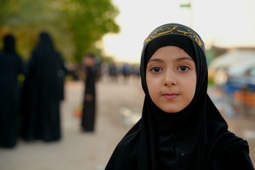 Free A young girl in traditional attire during the Arbaeen march in Karbala, Iraq. Stock Photo