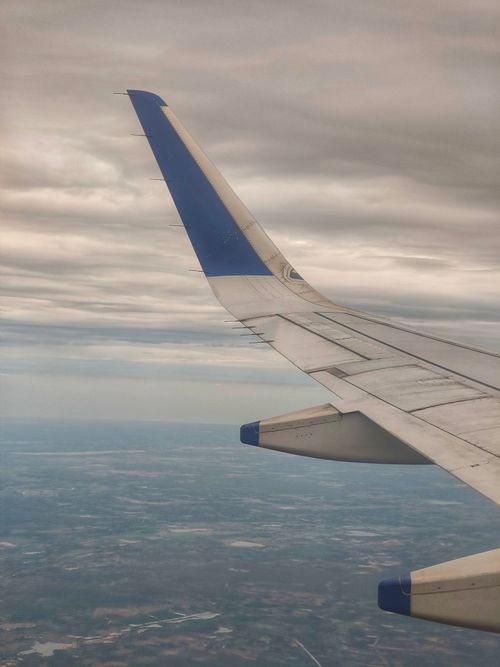 Free Airplane wing against a dramatic cloudy sky, offering a travel perspective. Stock Photo