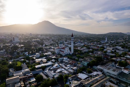 Stunning aerial view of San Salvador cityscape with a prominent church at sunrise.