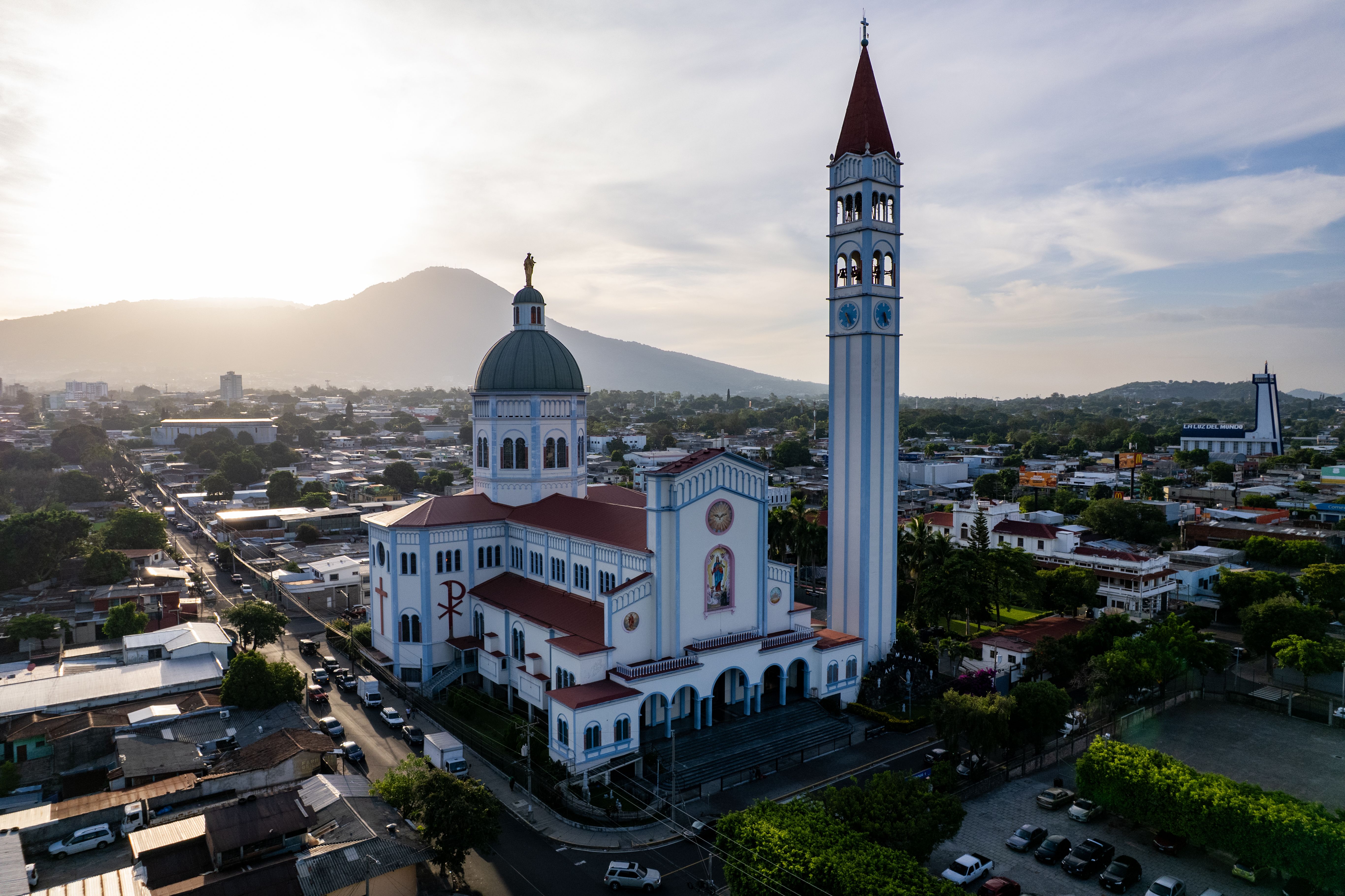 Aerial shot of Basílica Sagrado Corazón with a scenic mountain backdrop in San Salvador, El Salvador.