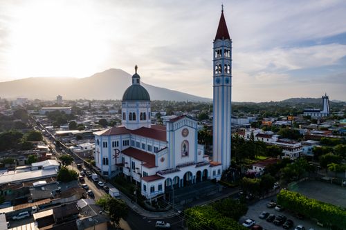 Free Aerial shot of Basílica Sagrado Corazón with a scenic mountain backdrop in San Salvador, El Salvador. Stock Photo