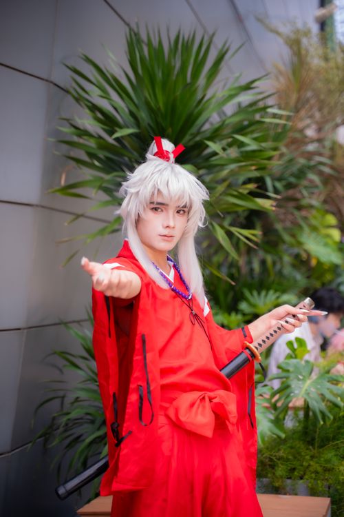 Free Cosplay enthusiast in vibrant red costume, holding a sword, outdoors. Stock Photo