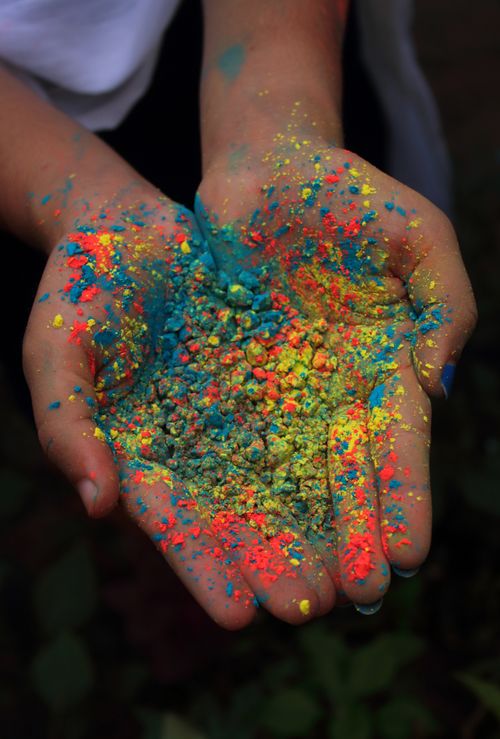 Free Hands holding vibrant Holi powder, symbolizing joy and celebration in India. Stock Photo