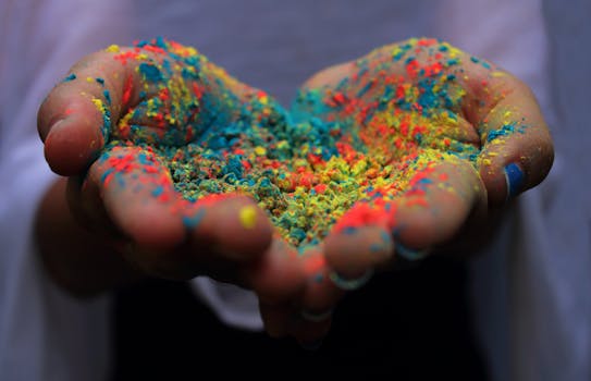 Close-up of hands holding vibrant Holi powder, symbolizing the Indian festival of colors.