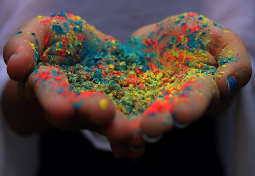 Close-up of vibrant colored powders held in hands during India's Holi festival.
