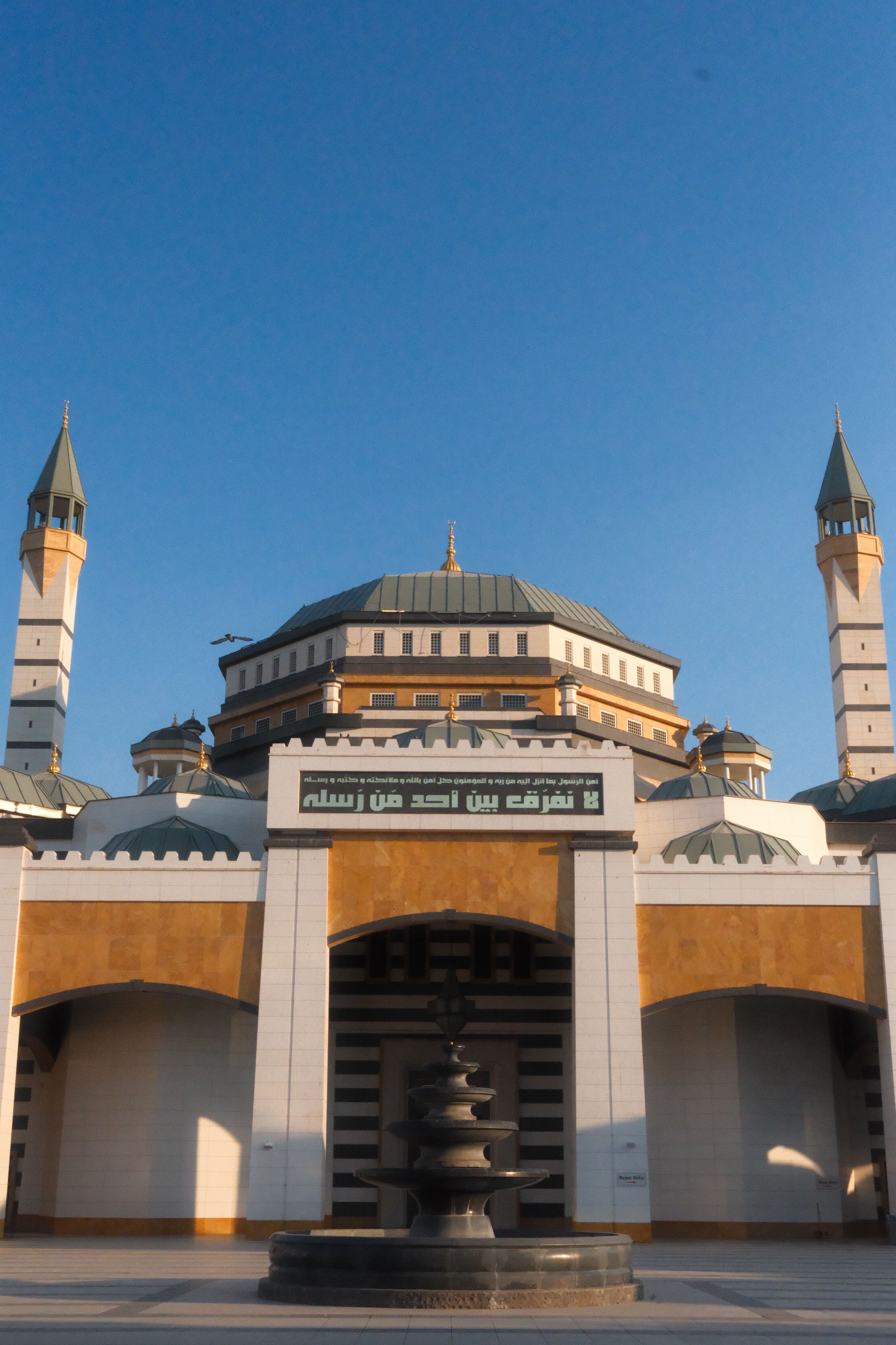 Striking mosque with minarets and intricate dome under clear blue skies, demonstrating architectural beauty.