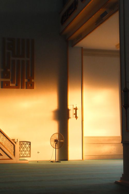 Free Golden sunlight streaming into a peaceful mosque interior, highlighting intricate decor. Stock Photo