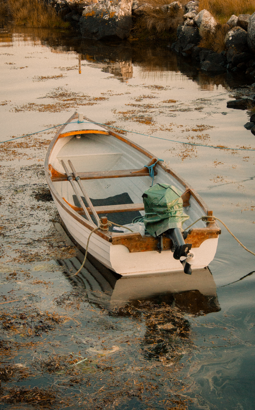 Free A peaceful scene of a traditional fishing boat moored in a calm inlet in County Galway, Ireland. Stock Photo
