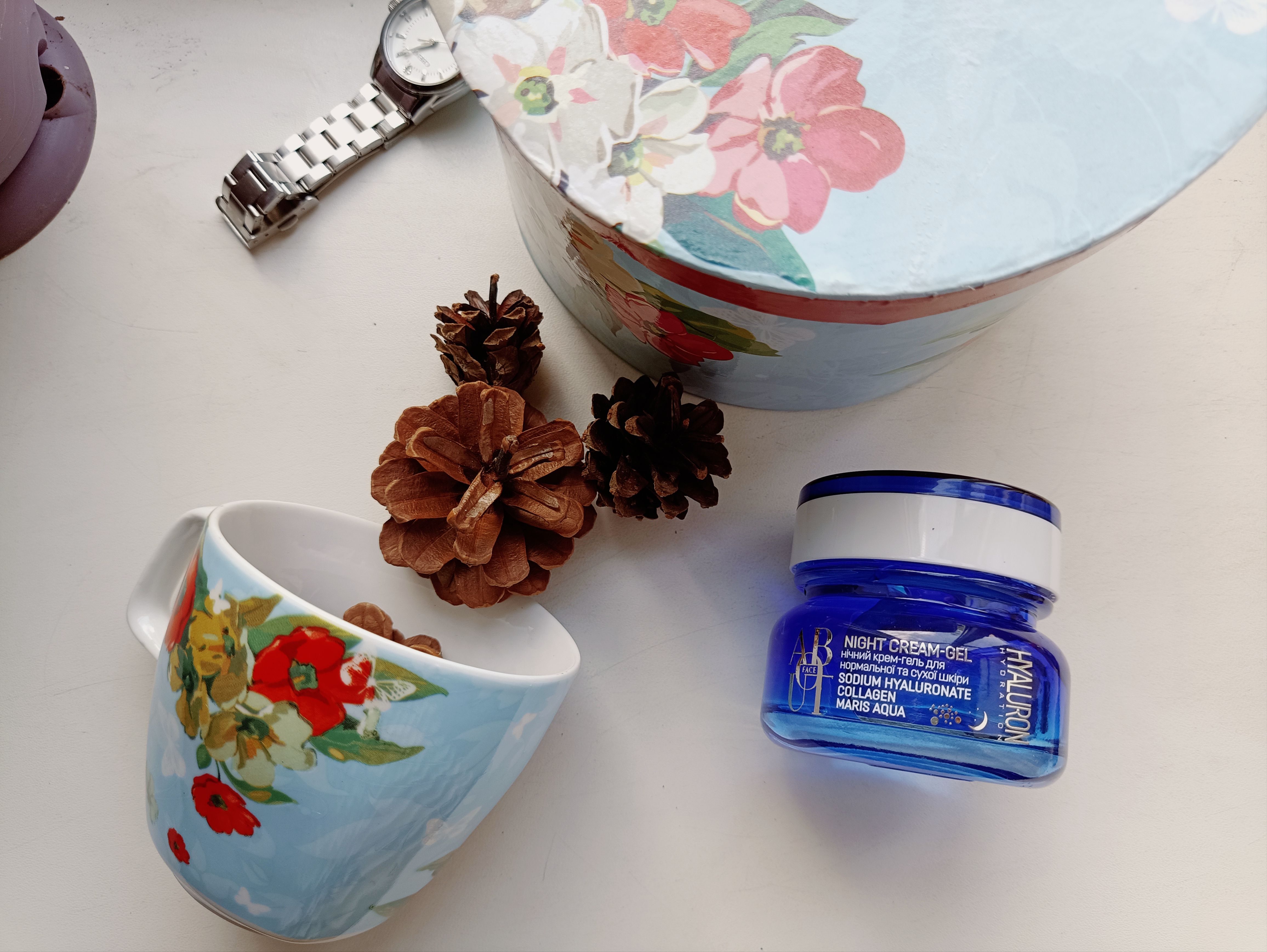 Floral-themed cozy flat lay with night cream, pine cones, and a floral cup. - Evidence evidence guide for sodium hyaluronate skin hydration randomized trial